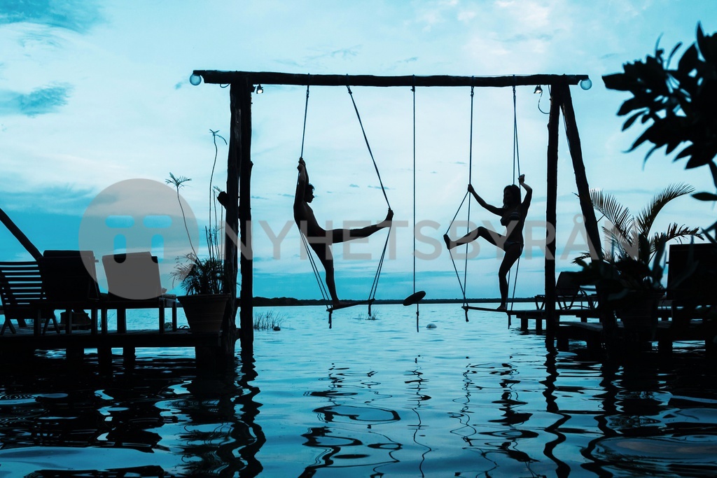 Silhouette of couple on the swings