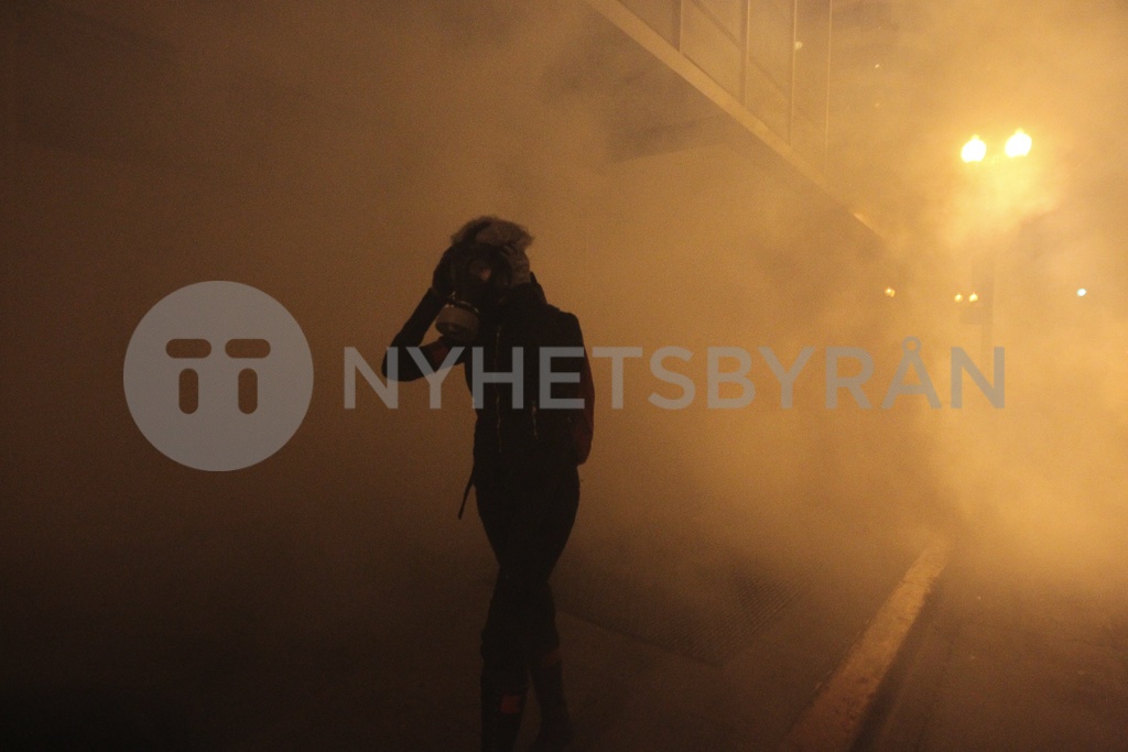 A masked Occupy Wall St. demonstrator walks away as authorities deploy ...