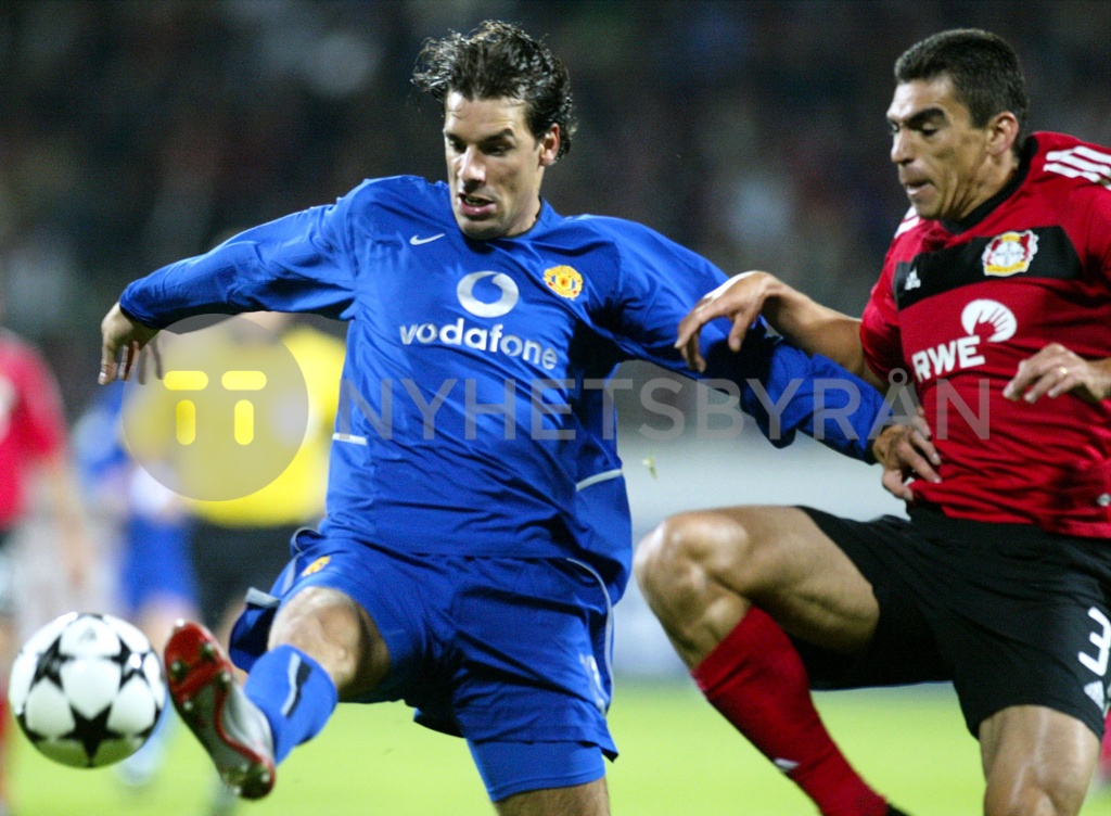 LUCIO OF LEVERKUSEN TACKLES VAN NISTELROOY OF MANCHESTER UNITED DURING